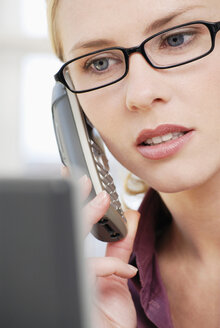 Woman in office using phone, close-up - VRF00047