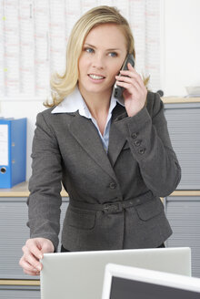 Woman in office using phone, close-up - VRF00039