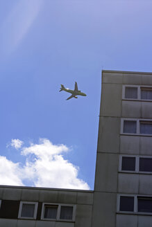 Flugzeug fliegt über Haus, tiefer Blickwinkel - TL00261