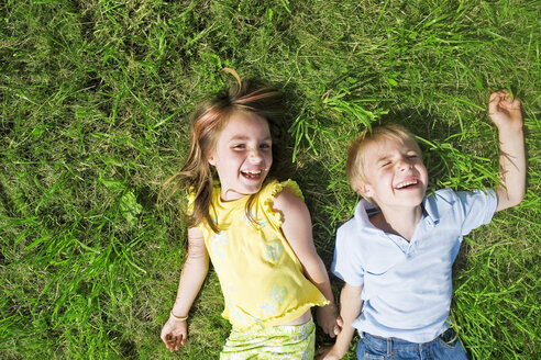 Girl and boy lying in meadow - LDF00530