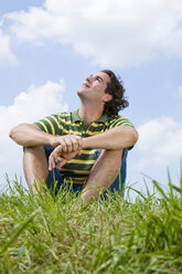 Man sitting in meadow, close-up - LDF00517