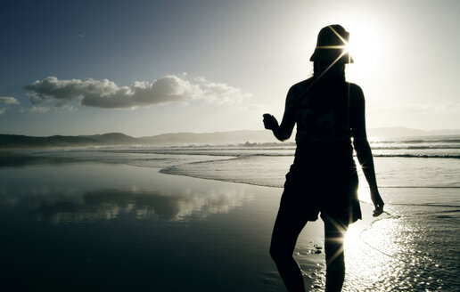 Neuseeland, Frau am Strand stehend, Rückansicht - PKF00237