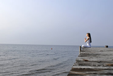 Italy, Lake Garda, Young woman (20-25) exercising yoga - DKF00114