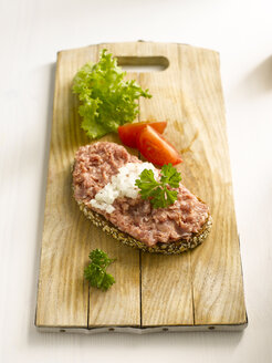 Brotscheibe mit Hackfleisch auf Schneidebrett, Nahaufnahme - KSW00041