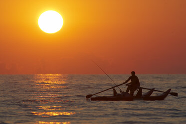 Italien, Forte dei Marmi, Mann fischt im Boot bei Sonnenuntergang - FFF00832