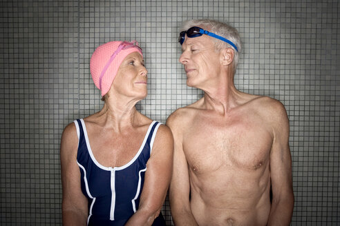 Senior couple in changing room, wearing swim cap and goggles - BABF00487