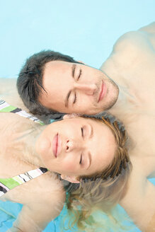 Germany, couple relaxing in swimming pool, portrait, close-up - BABF00338