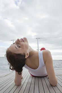 Germany, Baltic Sea, Lübecker Bucht, Young woman sitting on yacht, rear view - BAB00466