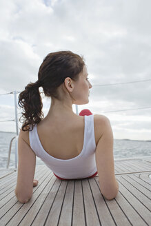 Germany, Baltic Sea, Lübecker Bucht, Woman sitting on yacht, rear view - BAB00465