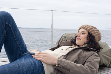 Deutschland, Ostsee, Lübecker Bucht, Junge Frau an Deck einer Yacht liegend, Porträt - BAB00418