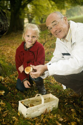 Deutschland, Baden-Württemberg, Schwäbische Alb, Großvater und Enkelin suchen Pilze im Wald, Portrait - WESTF06261