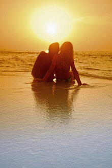 Paar am Strand sitzend, Silhouette bei Sonnenuntergang, Malediven - GNF00955