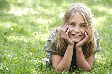 Girl lying on grass in garden - TCF00353