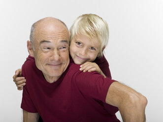 Grandson (8-9) embracing grandfather, smiling, portrait - WESTF06472