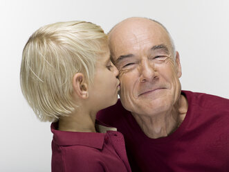 Grandson (8-9) kissing grandfather, portrait, close-up - WESTF06471