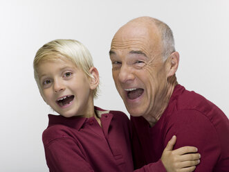 Grandson (8-9) embracing grandfather, smiling, portrait - WESTF06463