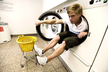 Junge (16-17 Jahre) spielt im Waschsalon, Porträt - MFF00362