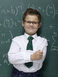 Boy (10-11) leaning against blackboard, smiling, portrait, close-up - WESTF06389