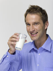 Junger Mann trinkt ein Glas Milch, Porträt - WESTF06365