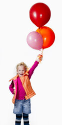 Girl (8-9) holding bunch of balloons, smiling, portrait - KMF01134