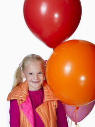 Mädchen (8-9) hält einen Strauß Luftballons, lächelnd, Porträt - KMF01132