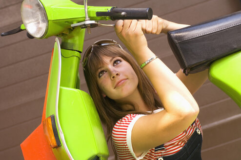 Junge Frau bastelt an einem Motorroller - HHF01566