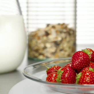 Erdbeeren auf dem Teller, Müsli und Milch im Hintergrund - CHKF00465