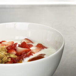 Muesli topped with yoghurt and slices of fresh strawberries, close-up - CHKF00463