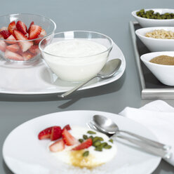 Joghurt und Erdbeeren in Glasschalen auf Teller, Nahaufnahme - CHKF00461