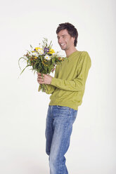 Junger Mann hält einen Blumenstrauß, Porträt, lächelnd - WESTF06870