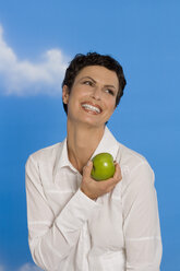 Junge Frau mit Apfel in der Hand, lächelnd, Porträt - RRF00097