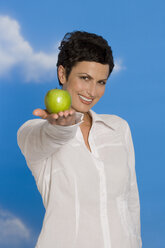 Junge Frau mit Apfel in der Hand, lächelnd, Porträt - RRF00095