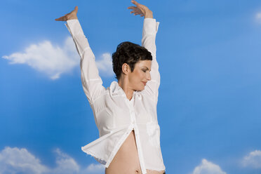 A Young Woman With Arms Stretched Out To The Sky Stock Photo