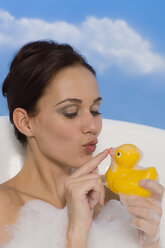 Junge Frau in der Badewanne mit Gummi-Ente, Porträt - RRF00019