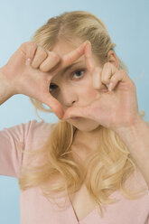 Blonde woman making hand gesture, portrait - WESTF07102