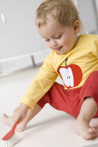 Baby girl (2-3) cleaning the floor stock photo