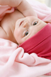 Baby girl (6-9 months) lying on back, portrait - SMOF00102