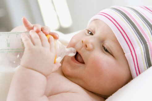 Kleiner Junge (6-9 Monate) trinkt Milch aus der Flasche, Porträt - SMOF00101