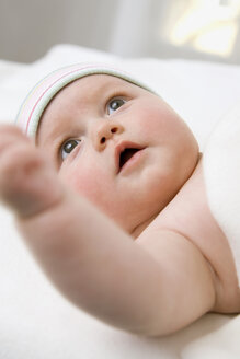 Baby boy (6-9 months) lying on bag, close-up - SMOF00096