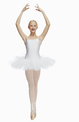 Young ballerina (14-15) standing on pointe in toe shoes,, portrait - KMF01165