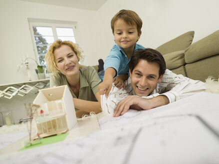 Junge Familie im Wohnzimmer, lächelnd - WESTF06663