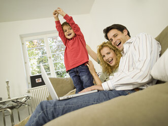 Young family in living room, smiling - WESTF06652