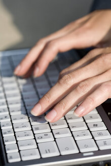 Weibliche Hand beim Bedienen der Tastatur eines Laptops, Nahaufnahme - MAEF00818
