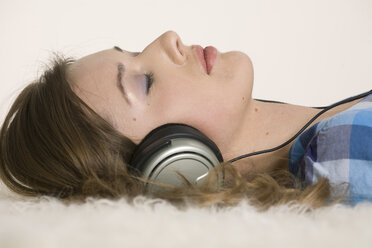 Young woman wearing headphones, eyes closed, portrait - CLF00555