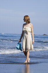 Woman walking along the beach - CLF00544