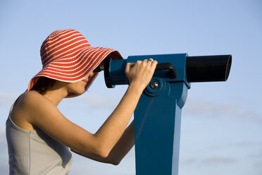 Young woman looking through telescope - CLF00540