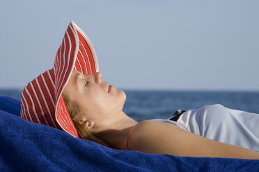 Frau mit Hut, am Strand liegend - CLF00538