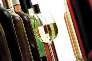 Glas Weißwein zwischen Weinflaschen, Nahaufnahme - 08128CS-U