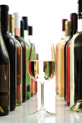 Glas Weißwein zwischen Weinflaschen, Nahaufnahme - 08123CS-U