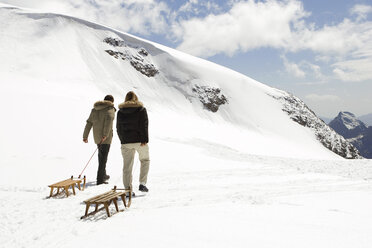 Italy, Cervinia, Matterhorn, couple with wooden sleds - FFF00841